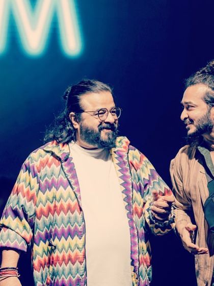 A candid moment of conversation and laughter with music director Pritam on stage.