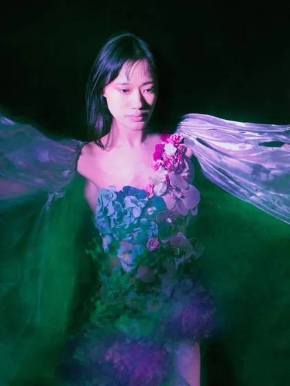 A portrait where the model is bathed in green light, suggesting an underwater environment. The expression and lighting convey a sense of serene melancholy.