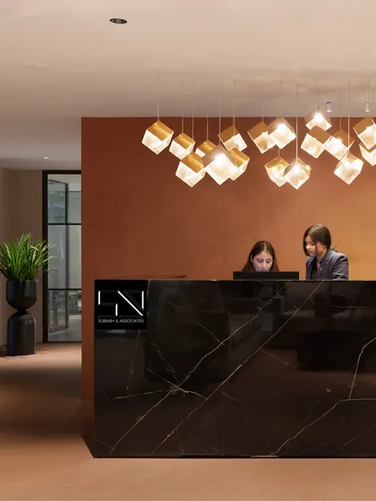 The reception at Jubilee Walk Headquarters, designed to be the first point of contact with the brand's ethos. The solid black marble desk, complemented by a cascade of geometric pendant lights, establishes an immediate sense of modern luxury and professionalism.