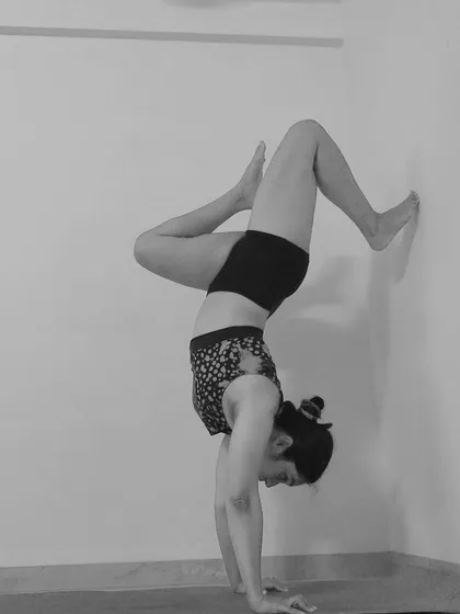 Another angle of a wall-assisted handstand. Notice how the legs are positioned to explore balance while still having the safety of the wall.
