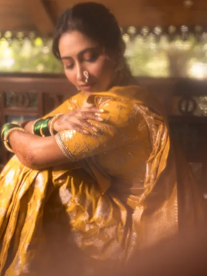A quiet, introspective moment, with a beautiful focus on the bride's face and henna.