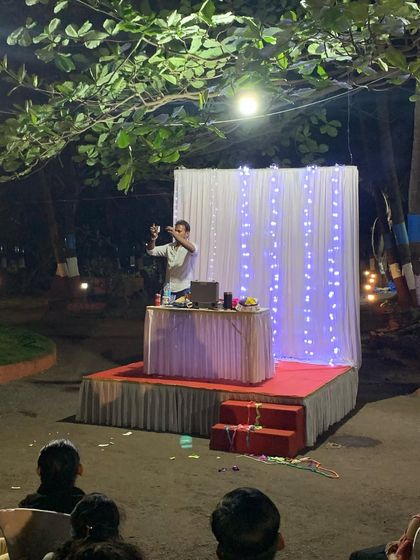 Here I am in the middle of a performance, set against a simple yet elegant stage setup. My act is adaptable to any venue, whether it's a large auditorium or an outdoor event space.