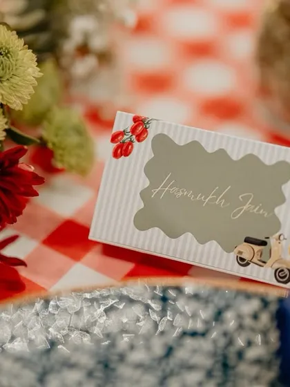 A custom place card for the Italian gala dinner, featuring a playful scooter illustration and the guest's name.