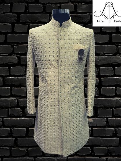 This shimmering ivory sherwani is designed for celebrations. The fabric has a subtle sparkle that catches the light beautifully, enhancing your look and luxury.