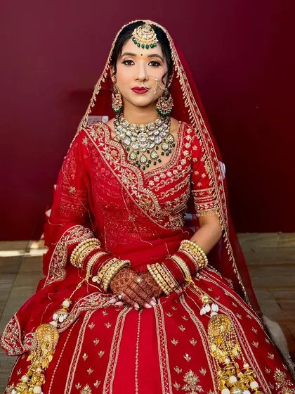 My NG bride Akanksha, looking like a doll in her red lehenga and beautiful green jewellery.