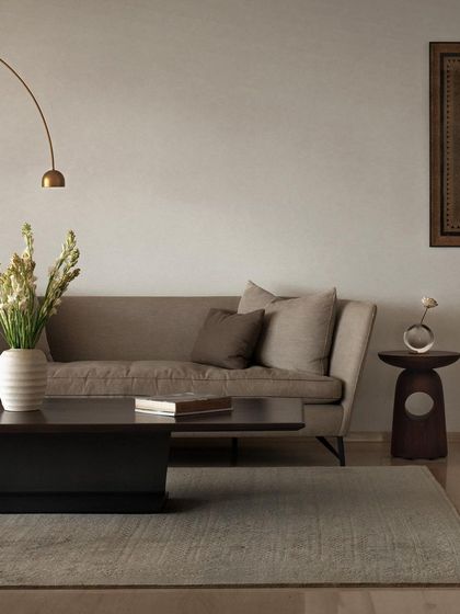 A closer look at the custom furniture in this living area. The solid base of the coffee table anchors the space, while the unique cut-out design of the wooden side table adds a touch of sculptural craft.