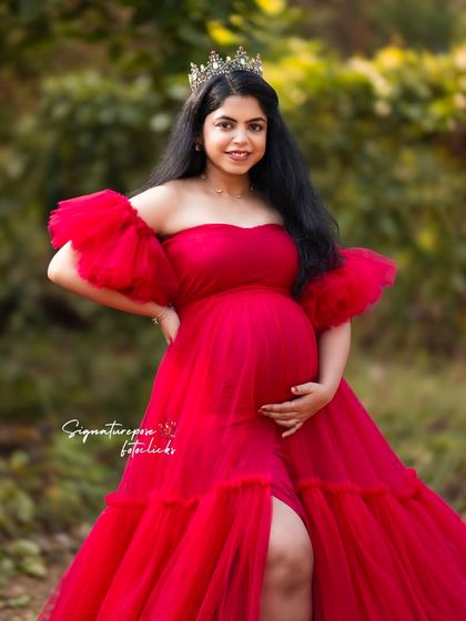 A close-up portrait in the outdoors, focusing on the mother's happy expression and the regal touch of a crown.