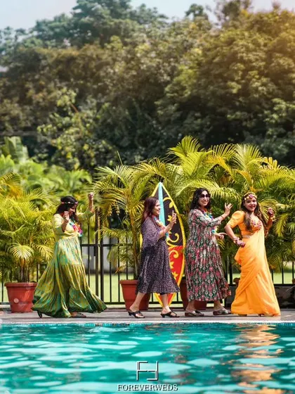The bride tribe making a splash. A fun, candid shot of the bridesmaids and friends enjoying a poolside Haldi party, showcasing the celebratory atmosphere.