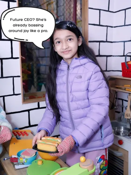 Future CEO in the making. This young girl is already bossing around joy like a pro in our pretend kitchen.