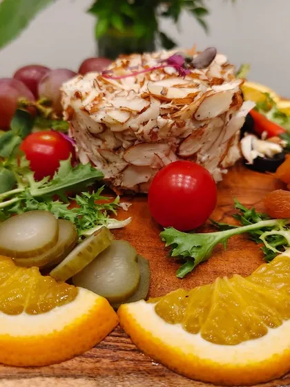 A board that speaks the universal language of indulgence. Creamy almond-crusted cheese is paired with citrusy oranges, tangy pickles, sweet grapes, and dried apricots.