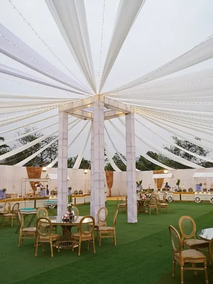 A breathtaking view of our tented outdoor setup. The flowing white drapes and elegant seating create a dreamy atmosphere for a wedding reception.