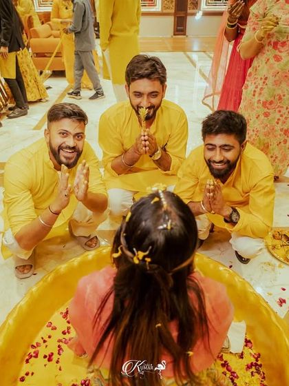 An overhead shot of the bride's friends paying their respects or sharing a fun moment during her haldi.