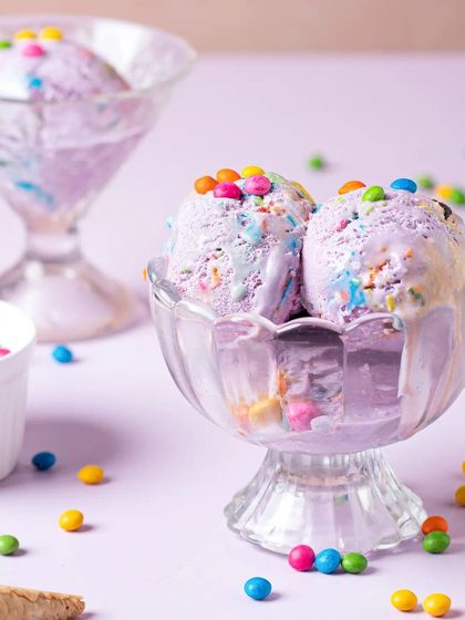 Scoops of colorful, candy-filled ice cream in a classic dessert glass. We create fun and vibrant scenes for summer treats and desserts.
