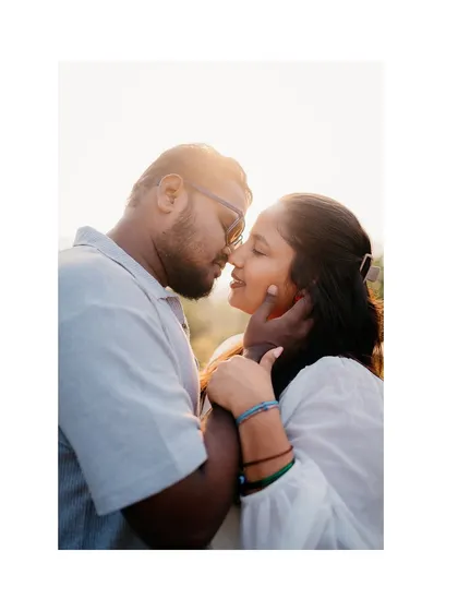 A close-up shot using the sun's flare to create a dreamy, romantic effect. It highlights the couple's connection in a soft, beautiful light.