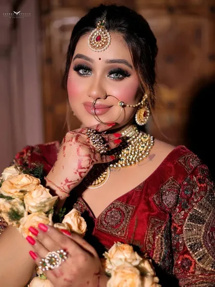 A bright, engaging close-up of the bride, showing off her radiant smile, nose ring, and floral jewelry.