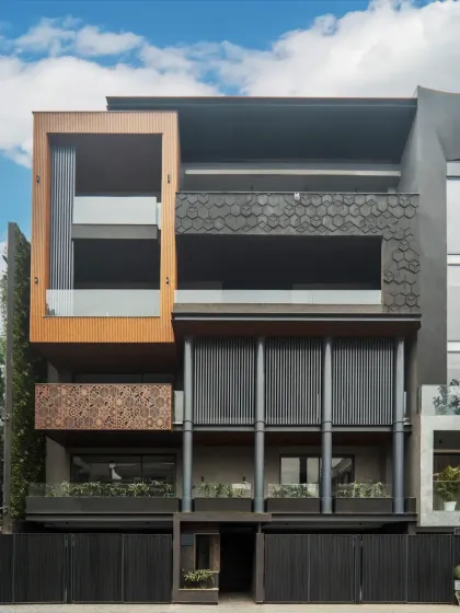 The stunning facade of a 500 sq. yd. project in DLF Phase 1, Gurgaon. The design incorporates a mix of materials, including striking MS columns, intricately designed MS jali, and sleek aluminum louvers for a dynamic and engaging look.