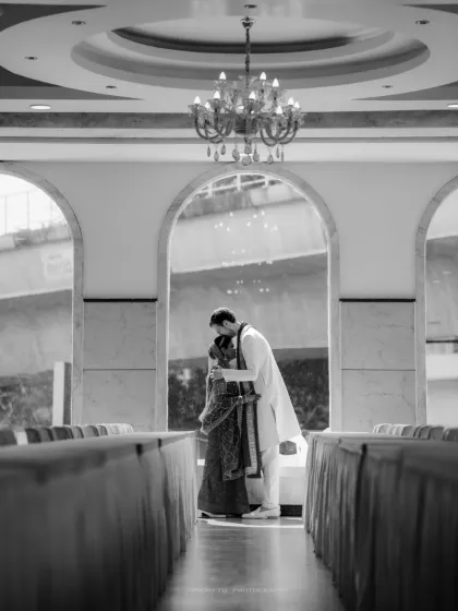 A timeless black and white shot of the couple sharing a private moment in a grand hall, creating a cinematic feel.