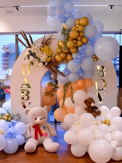The full baby welcoming setup, featuring a double arch, a cascade of balloons, fresh floral accents, and adorable teddy bears to complete the look.