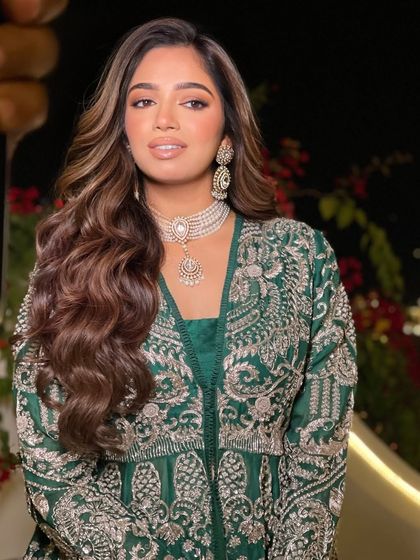 A beautiful open hairstyle with soft waves for a bride's evening function. The highlights add dimension to the curls.