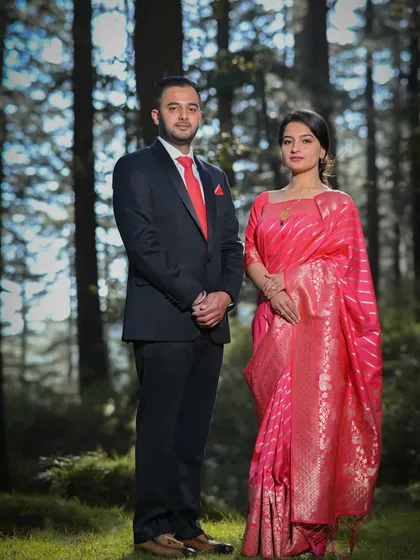 A classic and formal pre-wedding portrait taken in a pine forest. The soft, filtered light through the trees creates a timeless and romantic atmosphere, perfect for capturing a poised and elegant couple's photograph.