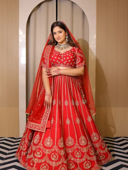 A full-length view of the red bridal lehenga, designed to flatter every curve. The A-line cut and the vertical embroidery create a beautiful silhouette.