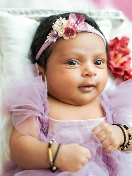 A close-up of this alert and beautiful baby. Her dark, curious eyes are the focus of this captivating portrait.