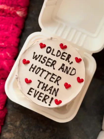 Another take on the "Older, wiser and hotter than ever!" message, this time on a cute bento cake surrounded by tiny red hearts.