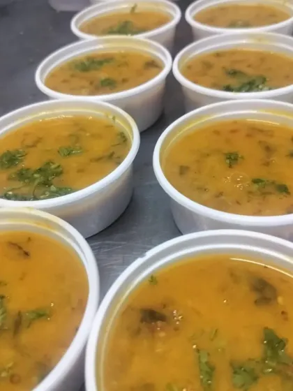 Portions of freshly made dal, ready to be packed for corporate orders. We prepare all our food in bulk while maintaining authentic, home-style taste.