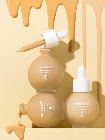 A playful tower of serum bottles with cascading drips of product. This shot is designed to be eye-catching and a little messy, showing off the serum's texture and color in a fun, unconventional way.