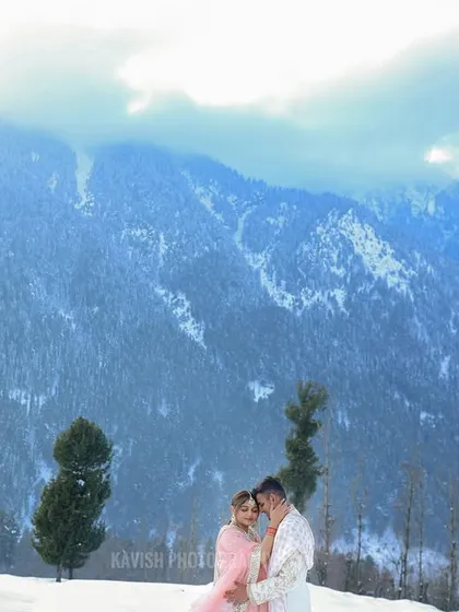 An epic pre-wedding portrait of the couple embracing, framed by the vast, beautiful mountain range. This shot captures the scale and romance of a destination photoshoot.