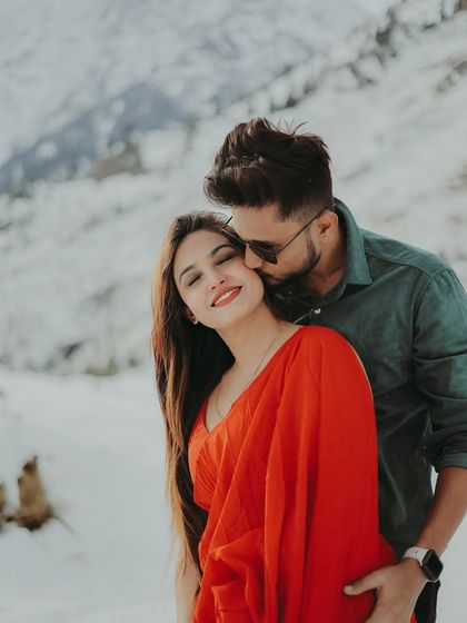 A sweet kiss on the cheek, full of affection and happiness, set against a beautiful snowy background.