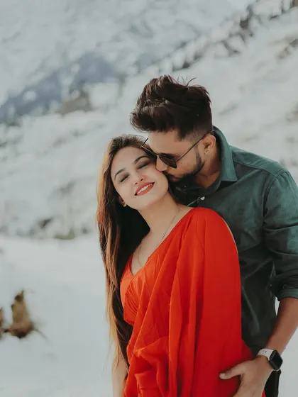 A sweet kiss on the cheek, full of affection and happiness, set against a beautiful snowy background.