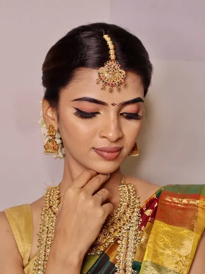 This angle highlights the beautiful eye makeup and contouring on the South Indian bridal look, demonstrating our students' attention to detail.