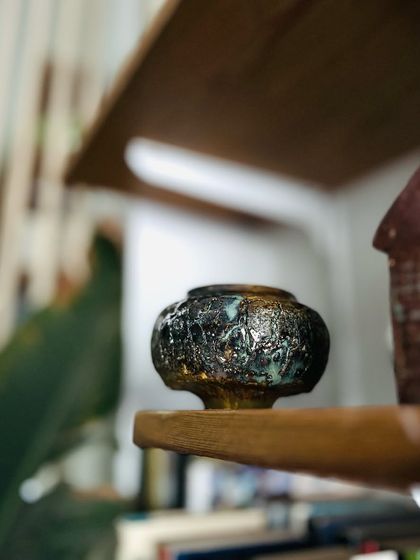 This small, intricate piece with a dark, metallic-looking glaze is one of those experiments that keeps us excited. You never know exactly what will come out of the kiln.