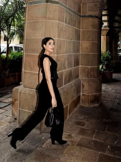 A walking shot of the black Mamkam jumpsuit, showing its movement and chic, minimalist vibe.