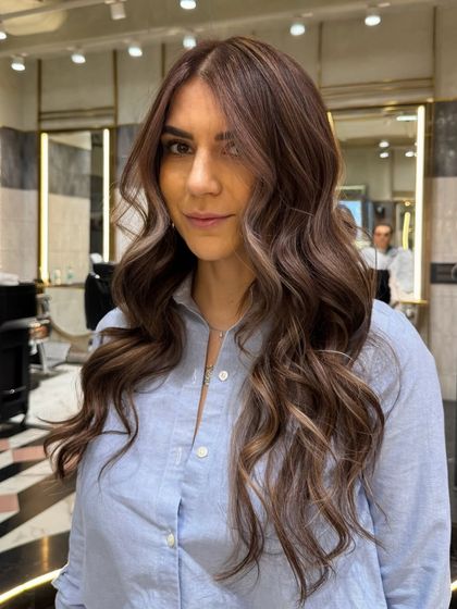 A closer look at this ash brown balayage with blonde highlights. The placement of the lighter pieces around the face brightens her complexion, while the soft waves show off the multi-tonal color.