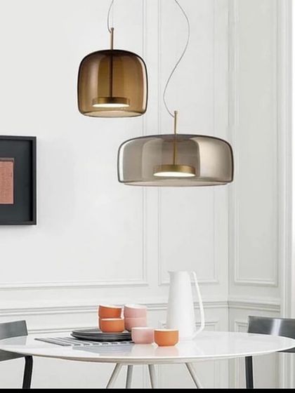 A pair of smoked glass pendants with a soft, modern shape. These are perfect for hanging over a dining table for an intimate feel.