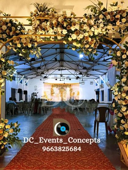 A grand floral entrance arch designed for a Holy Communion celebration. The lush white and yellow flowers create a welcoming and blessed pathway into the event hall.