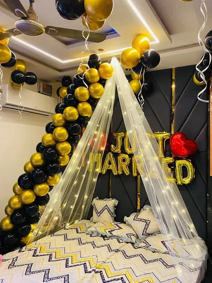 A slightly different angle of the black and gold "Just Married" setup, showing how the ceiling balloons and the main bed decor work together to fill the space.