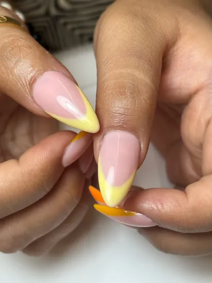 A detail shot of the colorful French tips, showing the smooth transition between the nude base and the vibrant, sharp tip line on these stiletto nails.