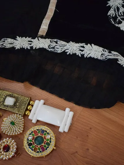 A detailed look at the delicate floral lacework on the black Anarkali. This kind of fine craftsmanship adds a layer of sophistication to the entire outfit.