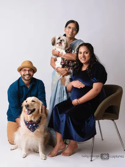 A happy, extended family maternity portrait including the grandmother-to-be and two beloved dogs. It’s a joyful celebration of family in all its forms, captured in a relaxed studio setting.