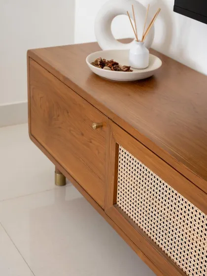 A detail of the 'Marshall' TV unit, showing the combination of a solid wood drawer and a woven rattan shutter.