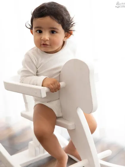 A classic portrait on a white rocking horse. Simple props like this are perfect for sitter sessions, allowing the baby's personality to shine.