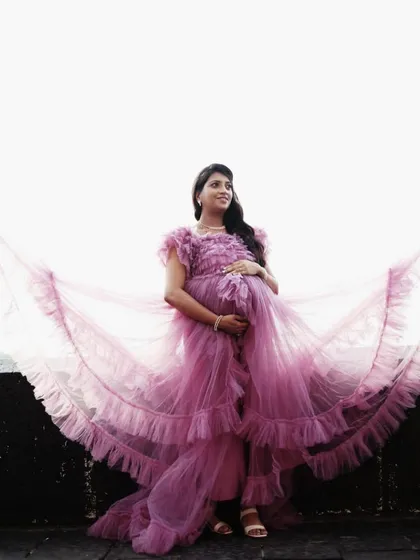 This gorgeous client is wearing a vibrant pink ruffled gown, with the layers of tulle creating a beautiful, wing-like effect. It's a perfect dress for feeling like a queen.