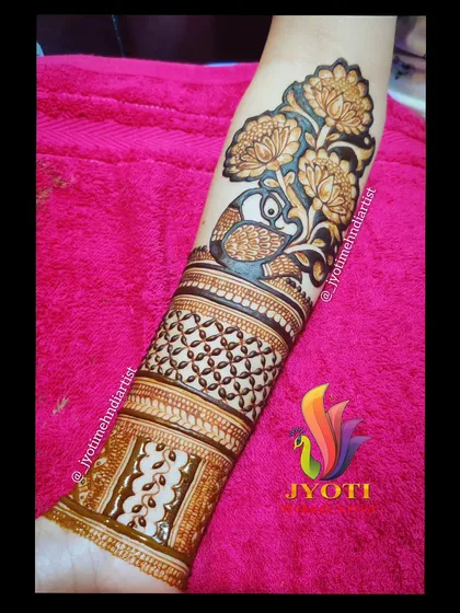 A bridal startup design showing a peacock amidst a garden of flowers on the upper arm. This is often the beginning point from which the rest of the arm's design flows.