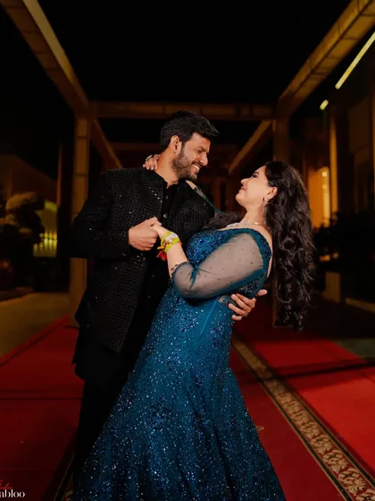 A candid moment on the red carpet during the sangeet night. The movement and genuine smiles create a dynamic and joyful portrait that captures the energy of the celebration.