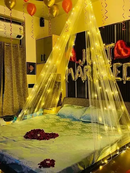 The "Just Married" cabana setup, showing the foil balloons and the sheer fabric canopy with integrated fairy lights for a dreamy effect.