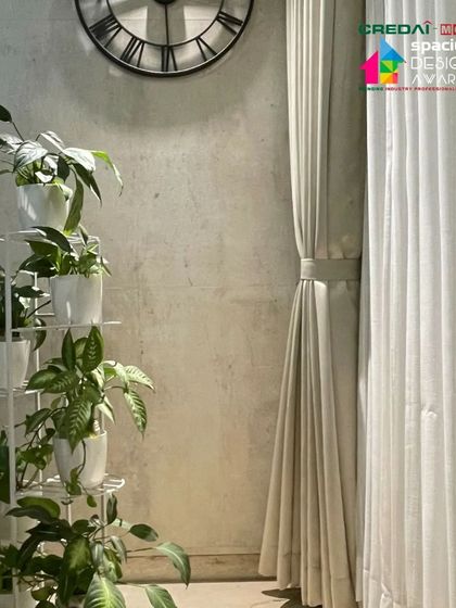 We believe in bringing nature indoors. A simple, elegant plant stand brings life and a touch of green to this corner, complementing the neutral tones of the wall and curtains.
