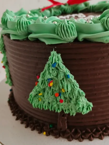 A close-up of the details on my Christmas wreath cake, including the little buttercream Christmas trees on the side. Every element is handcrafted to make your celebration special.